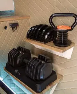 Adjustable dumbbells and kettlebell on a wall shelf