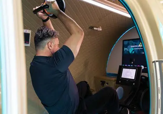 Guest training with a dumbbell inside the chamber