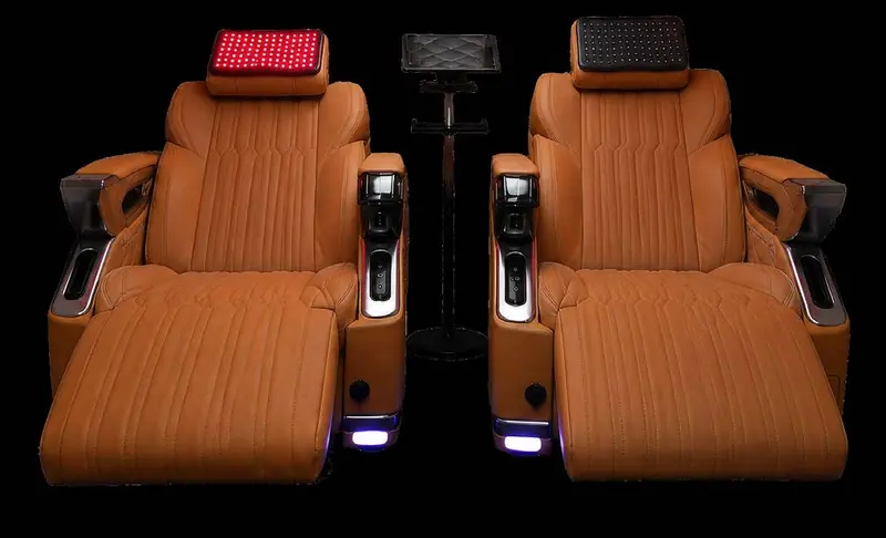 Two tan recliners with red light head panels, seen from the front